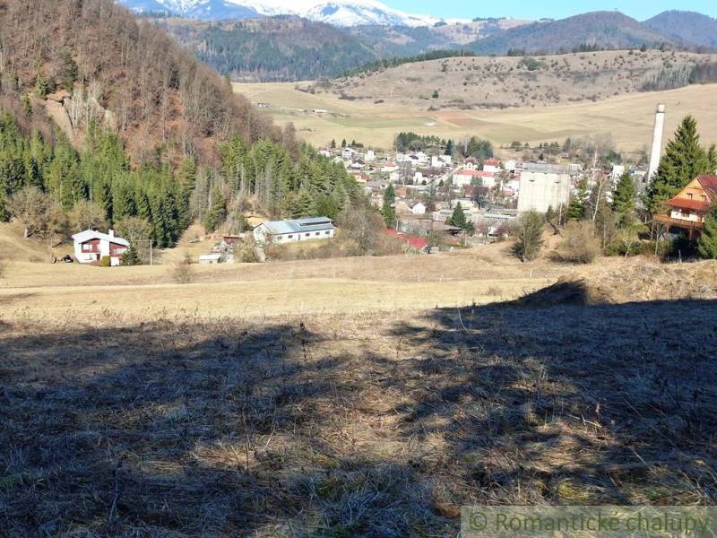 Výhled z pozemku na bydlení v Hronci obklopený horskou přírodou a lesy.
