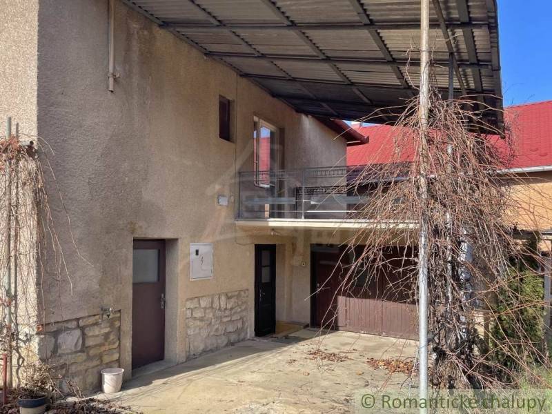 Rodinný dům v Bretce s balkonem, garáží a přístřeškem pro popínavé rostliny.