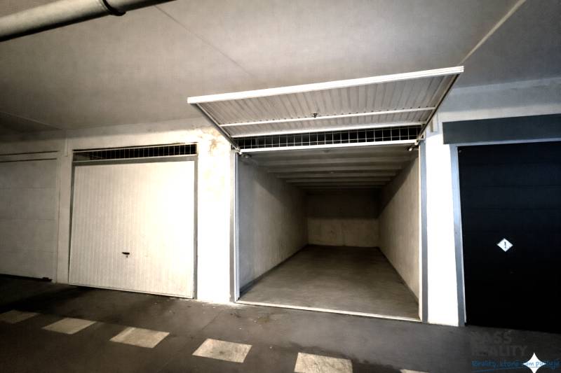 Otevřená garáž s prázdným interiérem a bílými stěnami.