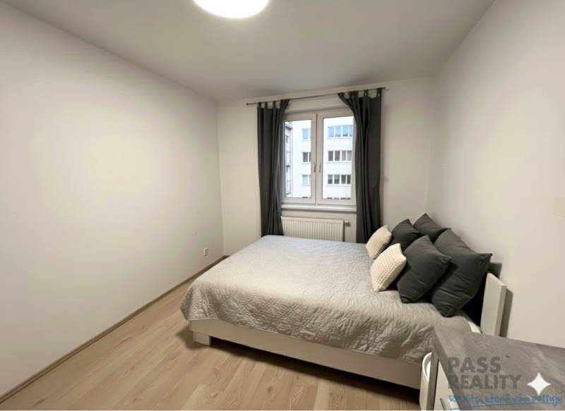 Ložnice s postelí a podlahou s dřevěným dekorem v 2-pokojovém bytě.