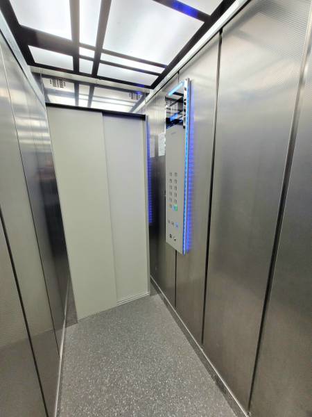 Kovový interiér a podlaha s dřevěným dekorem ve 2-pokojovém bytě.