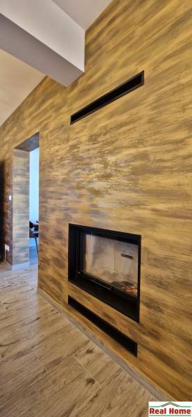 Interiér gastro prostorů s krbem a podlahou s dřevěným dekorem.