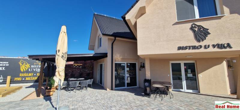 Exteriér gastro prostorů v Nové Dedince s terasou a moderním designem.