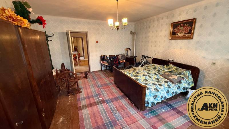 Pokoj v rodinném domě s tradiční postelí, šatní skříní a kolem.