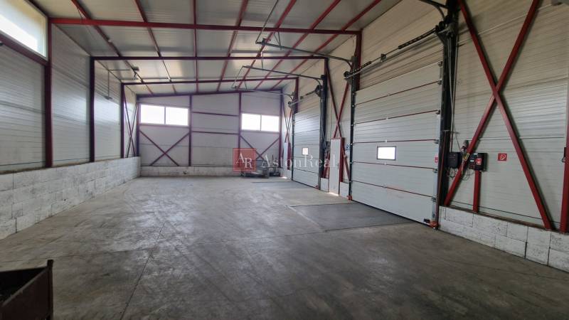 Prostorný prostor s vysokým stropem a velkými branami ve skladech a halách.