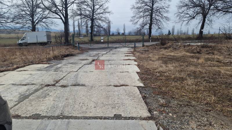 Areál s pevnou cestou a bránou ve Východní ulici v Popradu, sklady a haly.