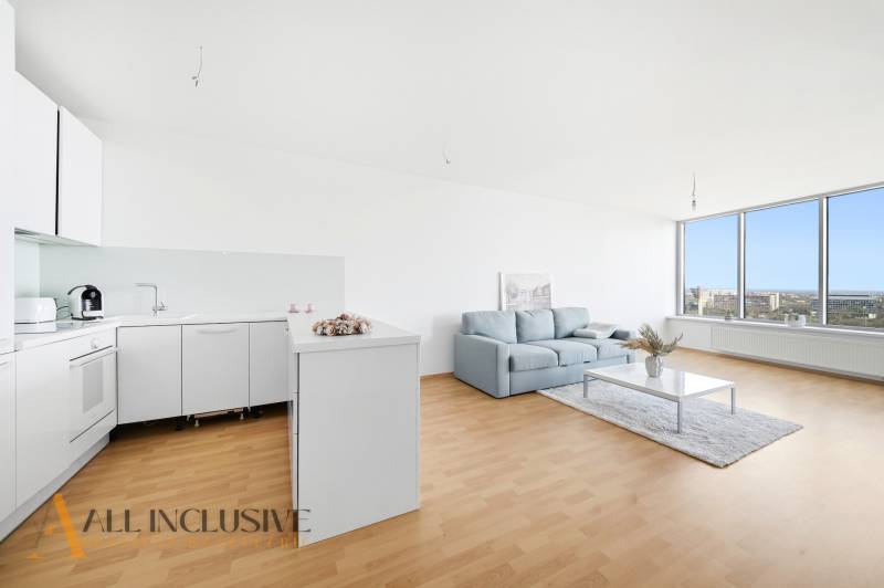 Útulná kuchyně s bílými skříňkami, sedačkou a velkou prosklenou stěnou ve 2pokojovém bytě.