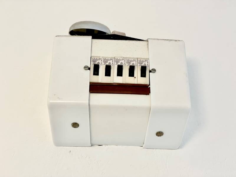 Život v jednopokojovém bytě s bílým plastovým krytem a vypínači.