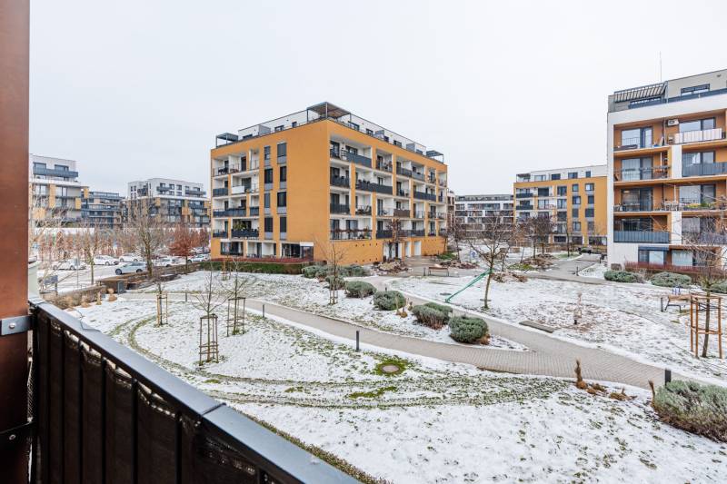 Sídlo obklopené zasněženými chodníky a zelení v Bratislavě - Petržalce na Béžové ulici.