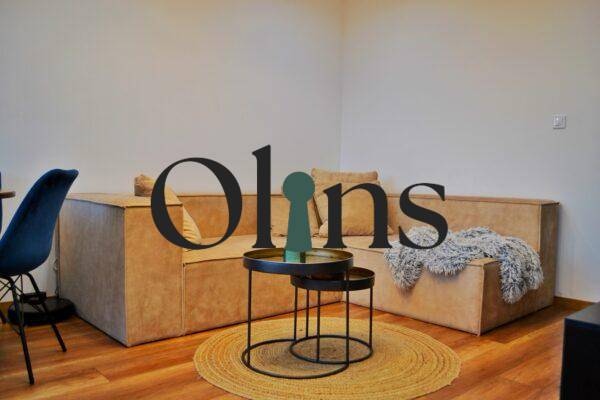 Obývací pokoj v 3pokojovém bytě s pohodlnou sedačkou a podlahou s dřevěným dekorem.