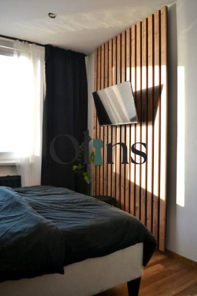 Ložnice s TV a podlahou s dřevěným dekorem v 3-pokojovém bytě.