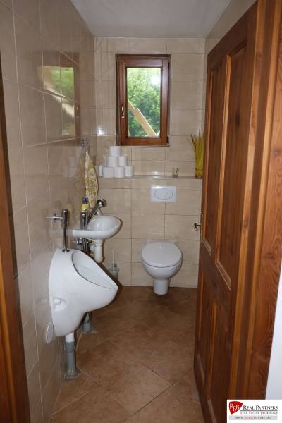 Malá koupelna s toaletou, pisoárem a umyvadlem, v 3-pokojovém bytě.