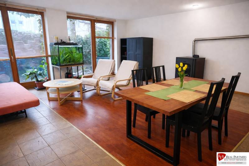 Obývací pokoj ve 3pokojovém bytě s podlahou s dřevěným dekorem, jídelním stolem a akváriem.