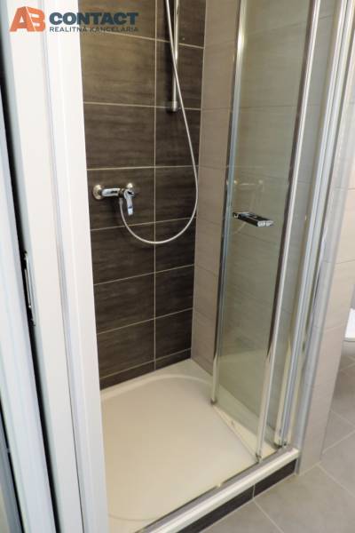 Sprchový kout s dveřmi nacházející se v garsonce na ulici Bodona.