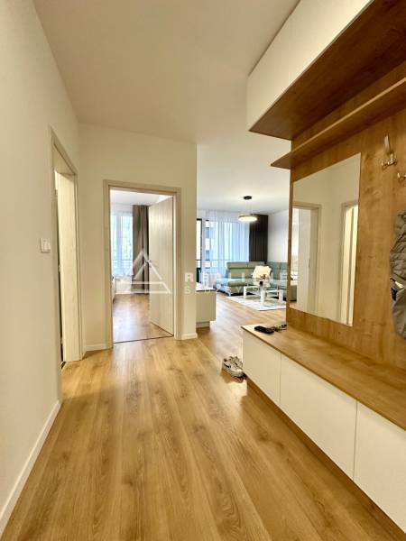 Chodba v 2-pokojovém bytě s podlahou s dřevěným dekorem a vestavěným nábytkem.