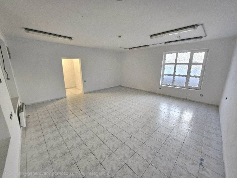 Prázdné obchodní prostory s dlažbou a oknem.