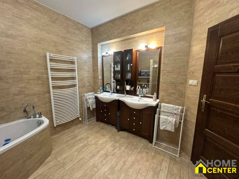 Koupelna v rodinném domě s podlahou s dřevěným dekorem a dvěma umyvadly.