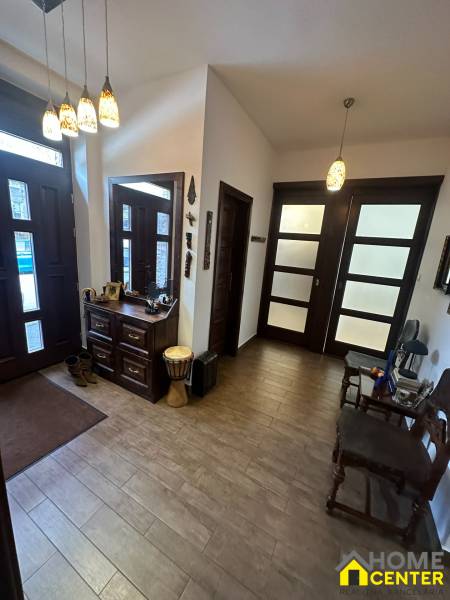 Interiér rodinného domu s podlahou s dřevěným dekorem, úložným prostorem a dekorativním osvětlením.