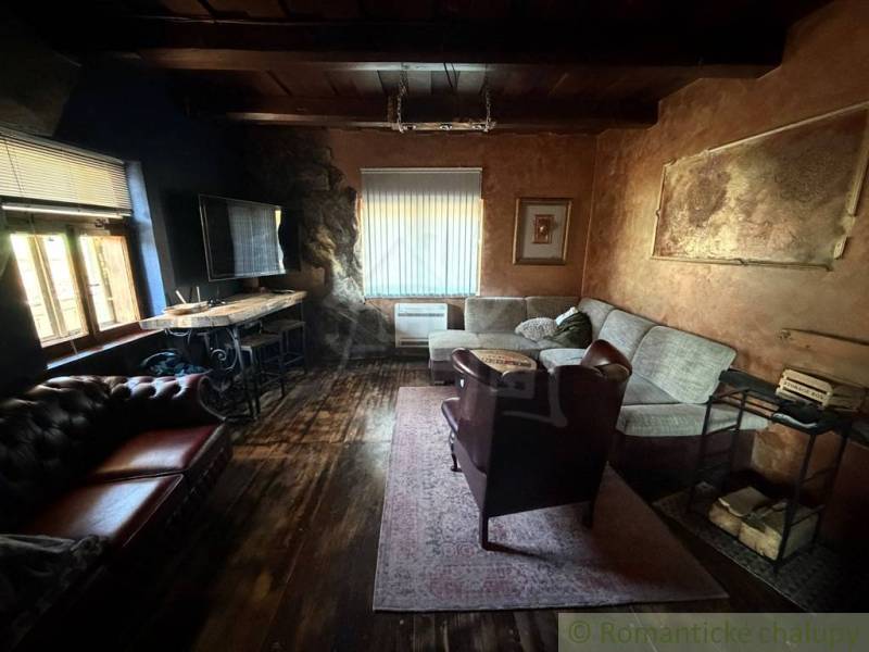 Obývací pokoj v rodinném domě s podlahou s dřevěným dekorem a pohodlným sezením.