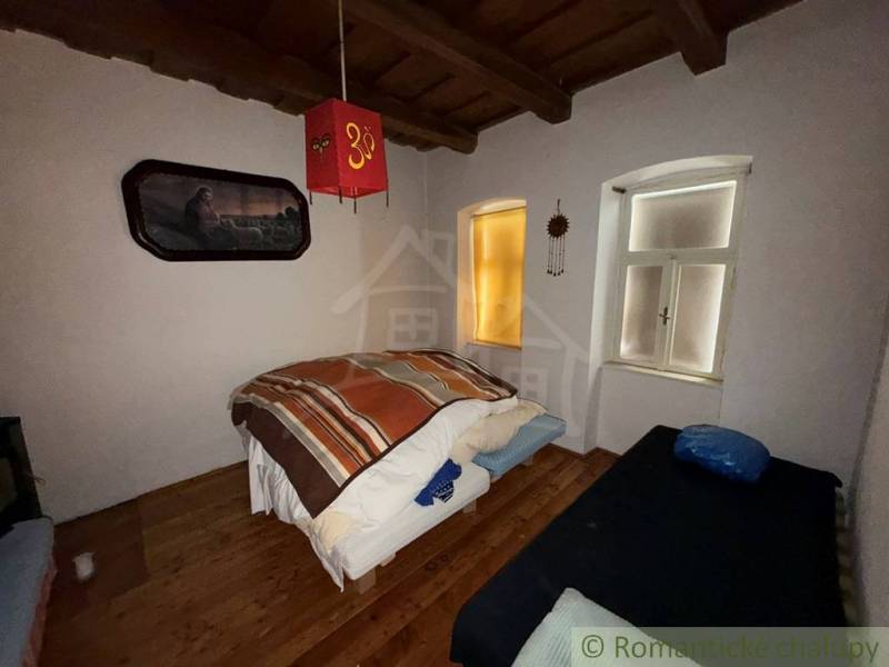 Ložnice v rodinném domě s dekorativními prvky a podlahou s dřevěným dekorem.