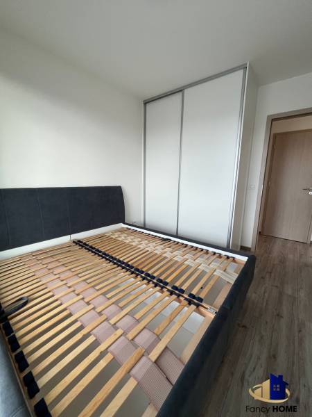 Ložnice v 3-pokojovém bytě s postelovým rámem a vestavěnou skříní.