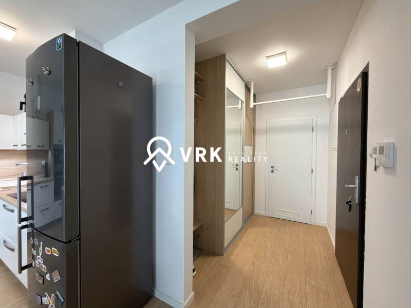 Kuchyně a předsíň v 3-pokojovém bytě s podlahou s dřevěným dekorem.