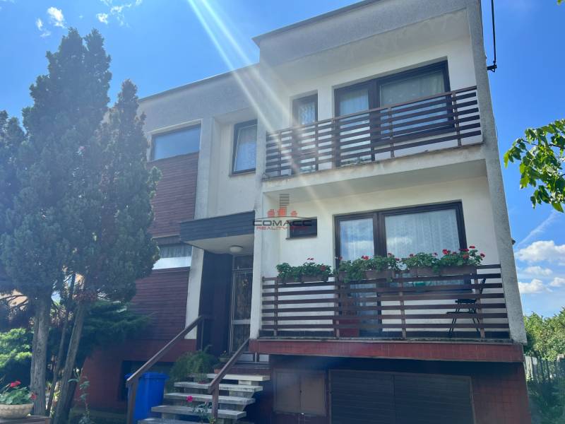 Rodinný dům na Tálové ulici ve Velkém Orvišti se dvěma balkony, dřevinami a garáží.