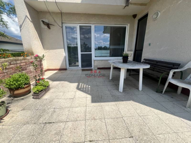 Terasa rodinného domu v Tálové ulici ve Velkém Orvišti s plastovým stolem a květinami.