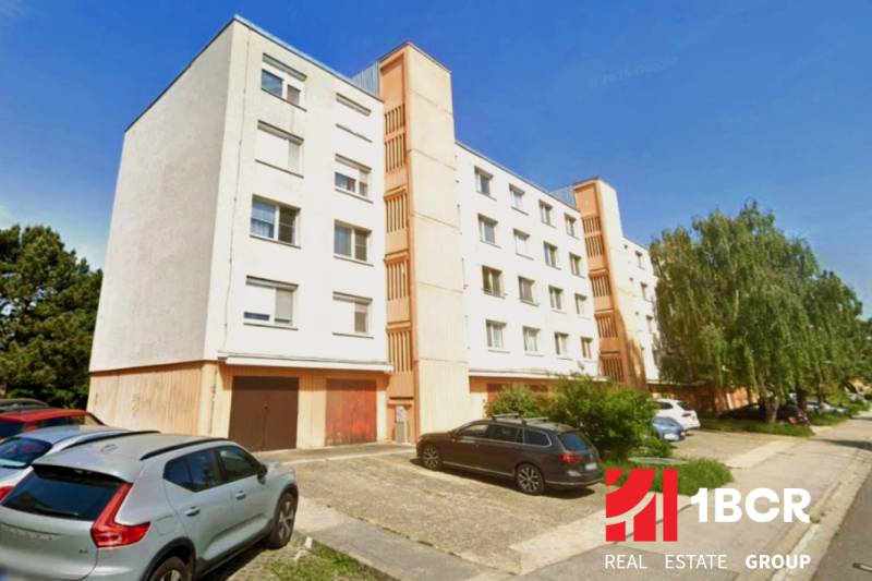 Bytový dům na Kalištnej ulici v Bratislavě - Devínské Nové Vsi, parkoviště v popředí.