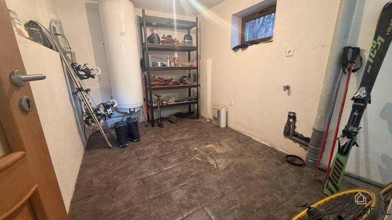 Skladovací prostor v rodinném domě s regálem a sportovním vybavením, podlaha s dřevěným dekorem.