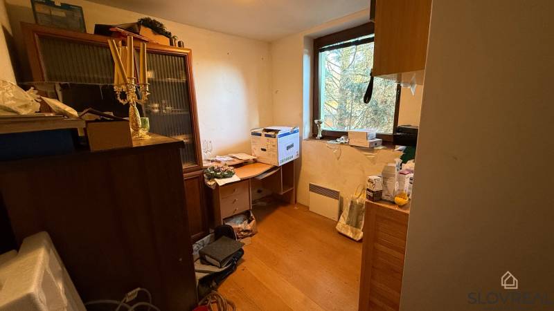 Pokoj v rodinném domě se zařízením a podlahou s dřevěným dekorem.