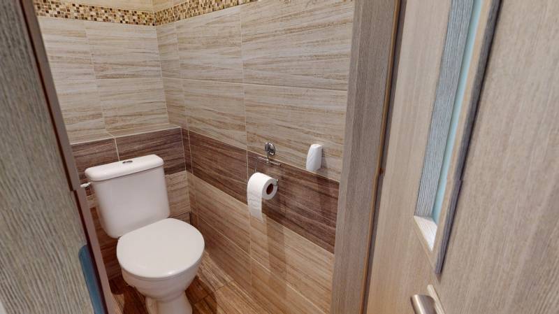 Koupelna se stěnami s dřevěným dekorem v 2-pokojovém bytě.