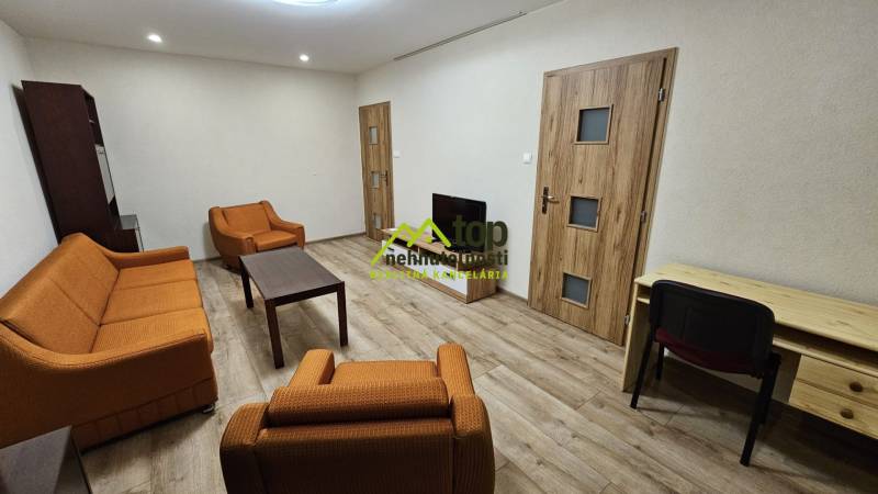 Obývací pokoj v 2-pokojovém bytě s oranžovým nábytkem a podlahou s dřevěným dekorem.