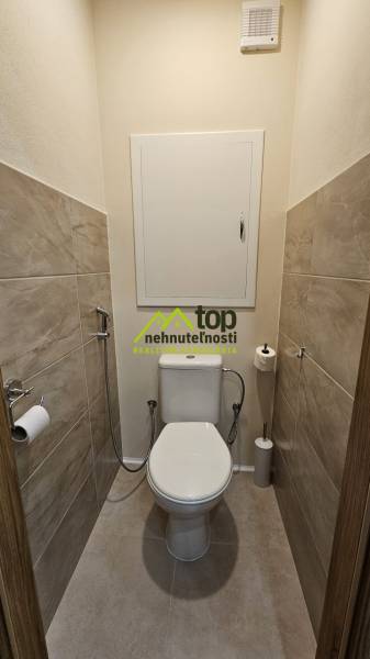 Toaleta s dlažbou a keramickou toaletou v 2-pokojovém bytě.