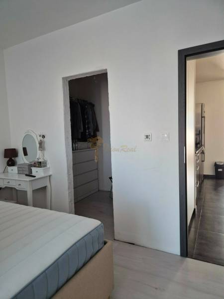 Ložnice se zrcadlem, vstupem do šatníku a chodbou v 3-pokojovém bytě.