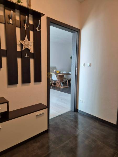 Chodba se sklápěcím nábytkem a výhledem do jídelny v 3-pokojovém bytě.