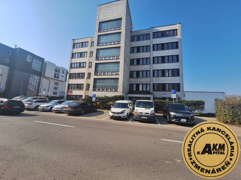 Budova kanceláří na ulici Tulská ve městě Zvolen, s parkovištěm a zaparkovanými auty.