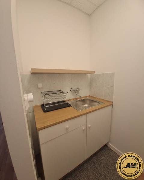 Kuchyňský kout s dřezem a odkapávačem, Budova, světlé obklady, bílá skříňka.