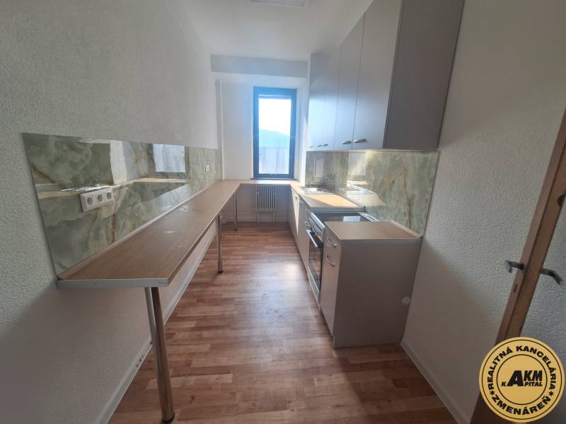 Kuchyně v budově s podlahou s dřevěným dekorem a zelenou kuchyňskou deskou.