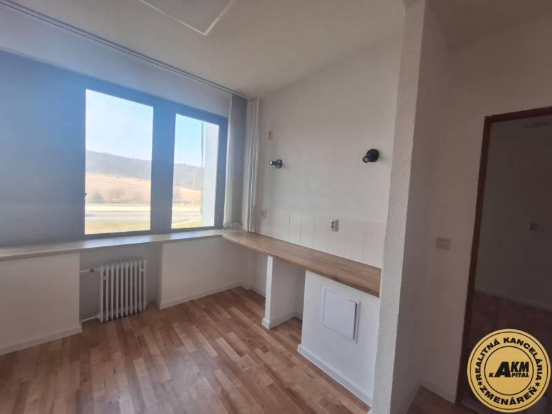 Obchodní prostory s podlahou s dřevěným dekorem a velkým oknem.