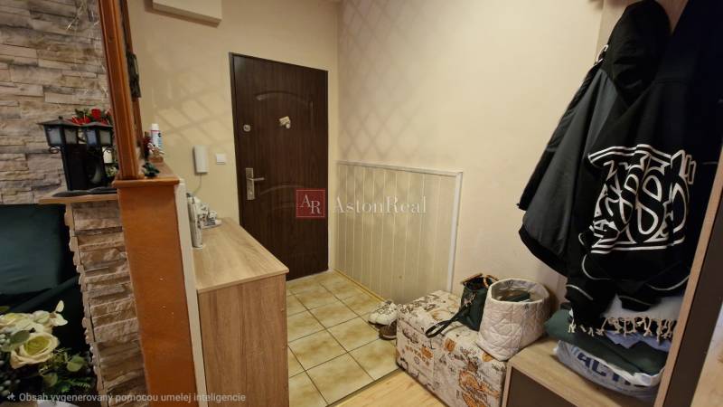 Vstupní hala ve 3-pokojovém bytě s kamenným obložením a úložnými prostory.