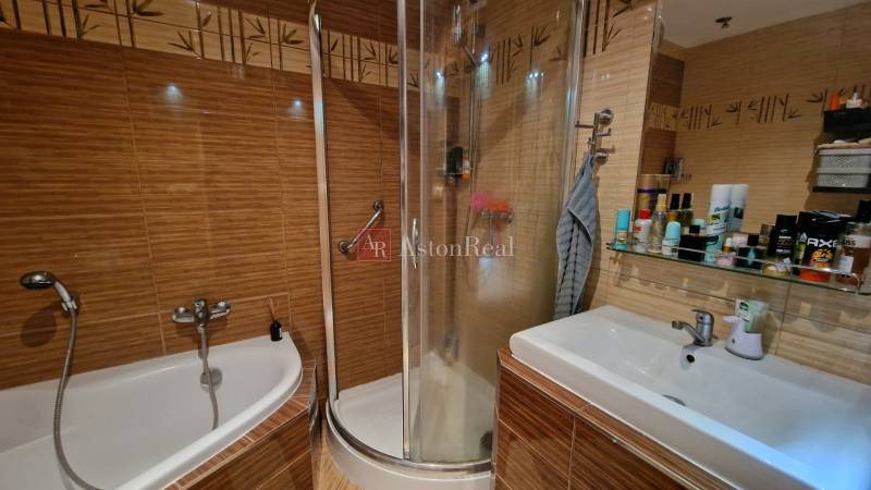 Koupelna v 3-pokojovém bytě s vanou, sprchovým koutem a umyvadlem.