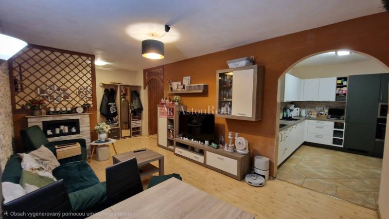 Obývací pokoj ve 3-pokojovém bytě s podlahou s dřevěným dekorem a otevřenou kuchyní.