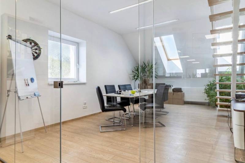 Skleněné stěny, podlaha s dřevěným dekorem a schody v kanceláři.