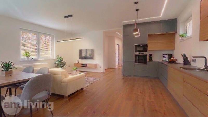 Obývací pokoj v rodinném domě s pohovkou a podlahou s dřevěným dekorem.