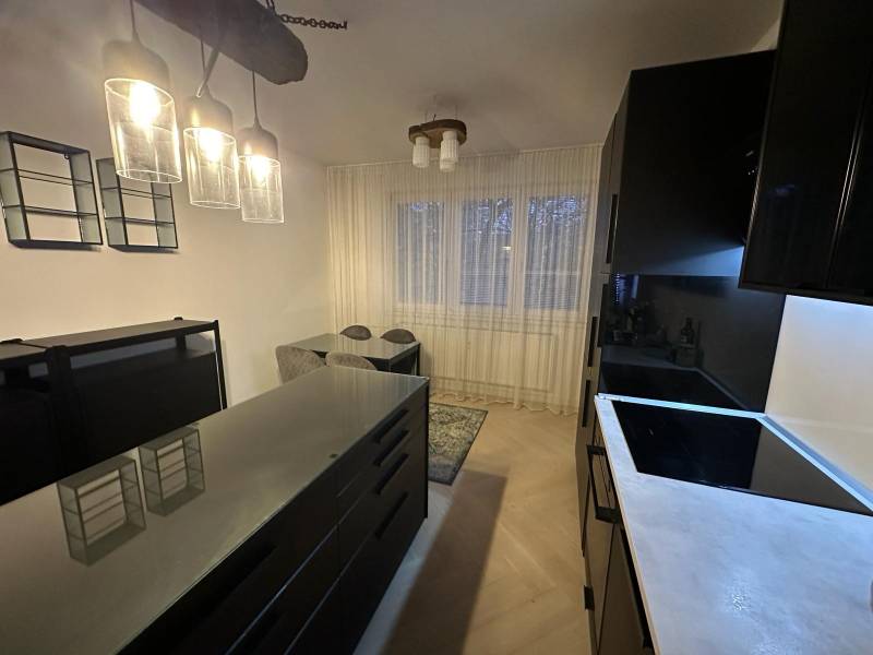 Kuchyně v 2-pokojovém bytě se skleněnými svítidly a podlahou s dřevěným dekorem.