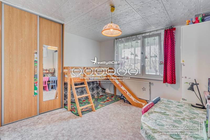 Dětský pokoj s patrovou postelí, skříňkami a barevnými křesly ve 4-pokojovém bytě.