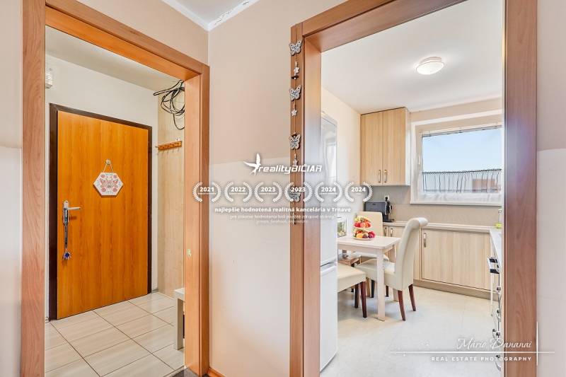 Interiér 4-pokojového bytu s podlahou s dřevěným dekorem a světlou kuchyní.