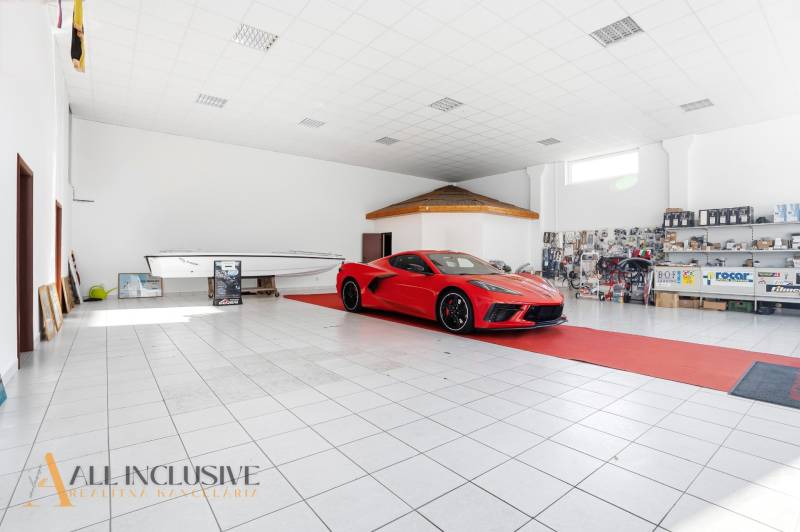 Červené auto a člun v obchodních prostorách na prodej v Štúrově.