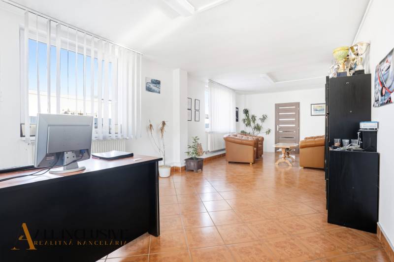 Světlé obchodní prostory s křesly, stoly a dekoracemi na podlaze s dřevěným dekorem.